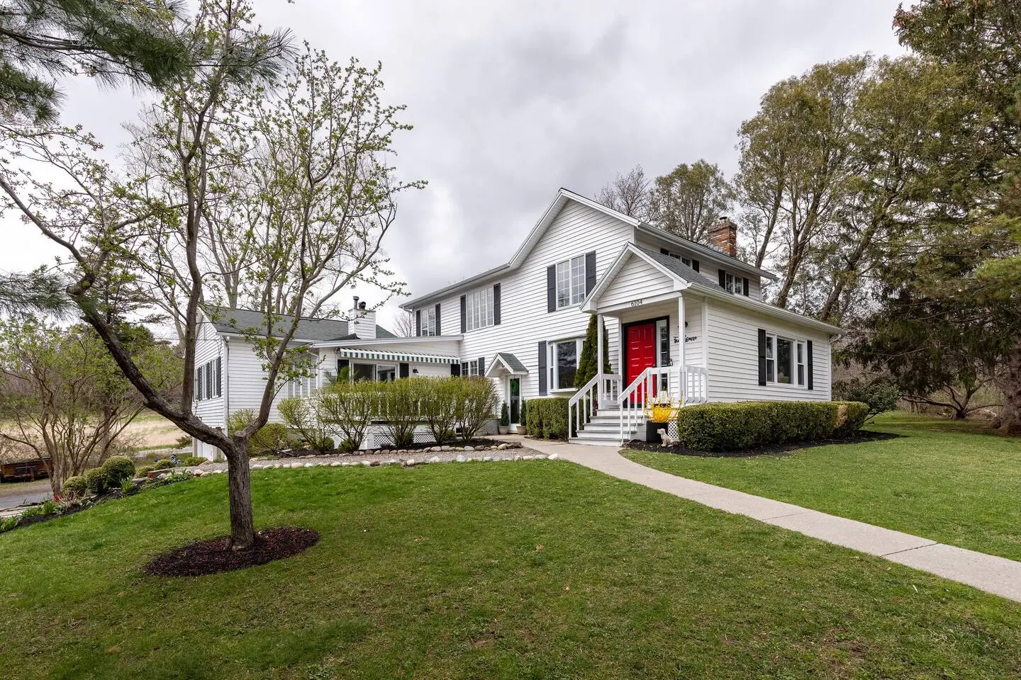 Side view of the white farmhouse and lawn