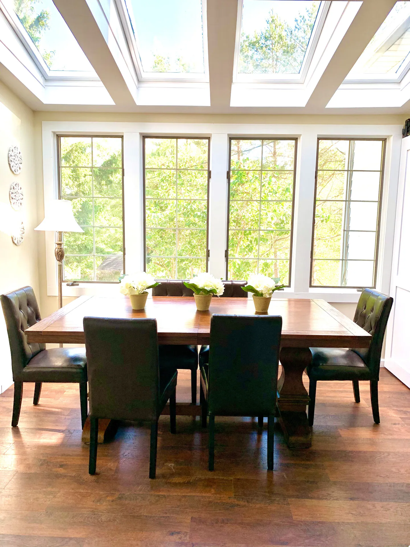 Dining table beneath skylights overlooking trees